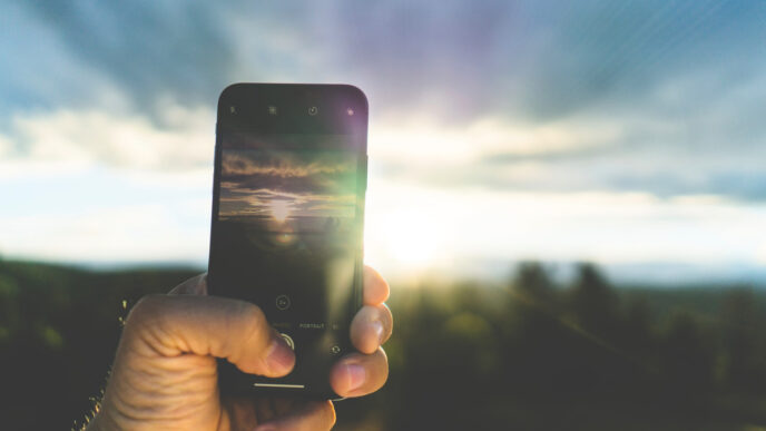 Un fotografo scatta una foto a un paesaggio con il proprio smartphone